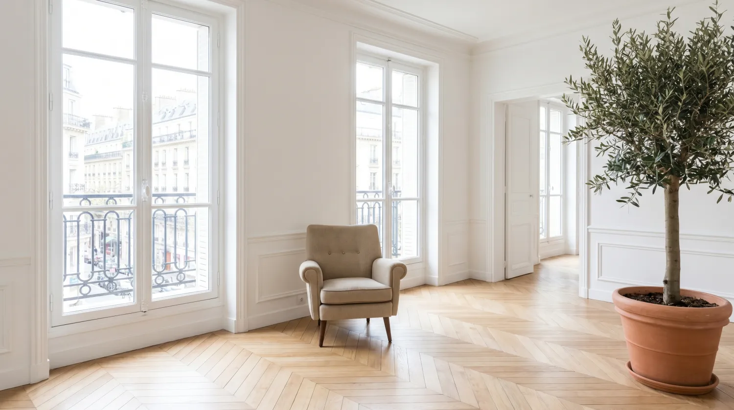 Pièce fraîchement rénovée aux murs blancs et parquet neuf